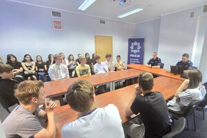Na zdjęcu widzimy policjanta oraz uczniów w czasie prelekcji przeprowadzonej na terenie bieruńskiej komendy