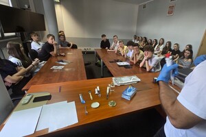 Na zdjęcu widzimy policjanta oraz uczniów w czasie prelekcji przeprowadzonej na terenie bieruńskiej komendy
