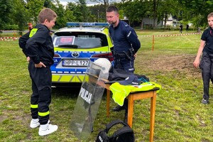 Na zdjęciu widzimy policjanta oraz uczestników festynu