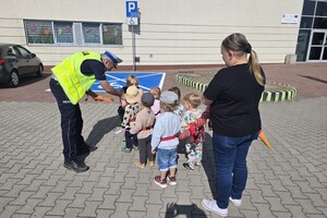 Na zdjęciu widzimy policjanta dającego odblask pieszym
