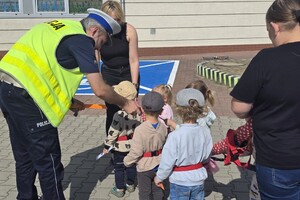 Na zdjęciu widzimy policjanta dającego odblask pieszym