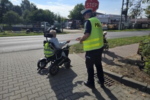 Na zdjęciu widzimy policjanta dającego odblask pieszym
