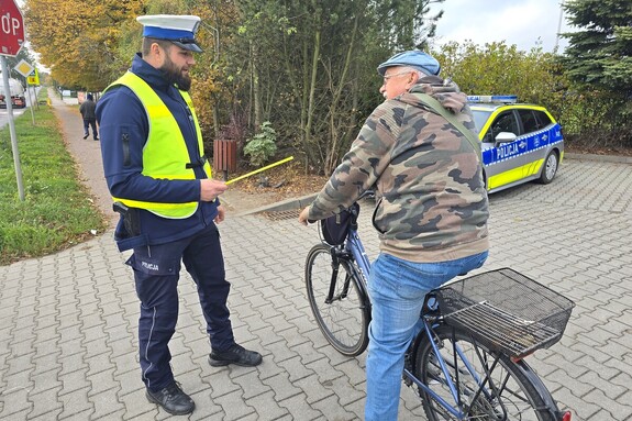 Na zdjęciu widzimy policjanta rozdającego odblaski